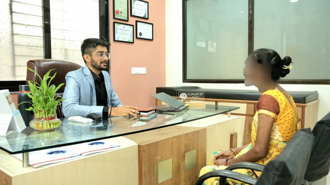 Dr. Dharmik Ahir consulting at Bliss Hospital Bapunagar Ahmedabad — psychiatrist consultation room